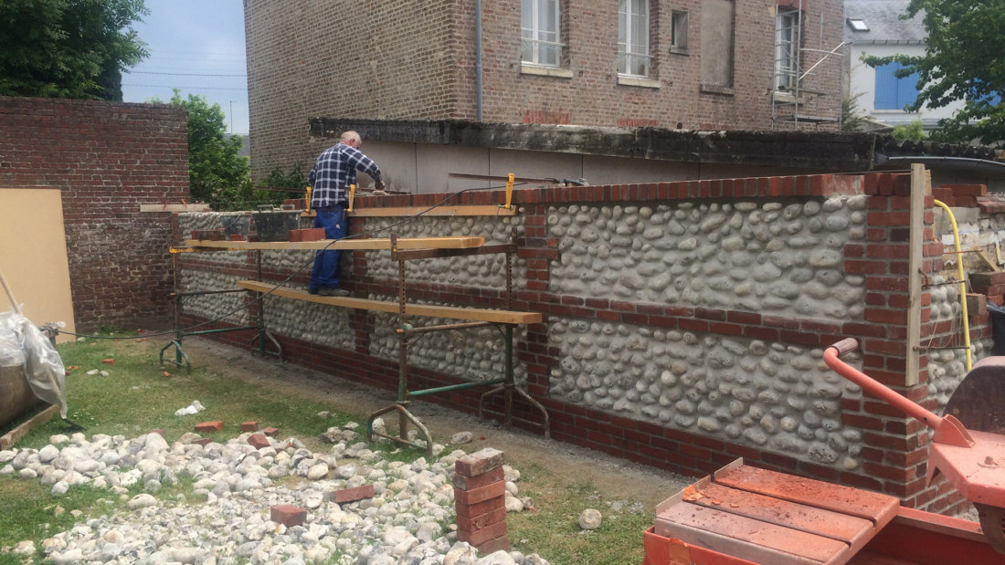 Mur de clôture en briques et galets